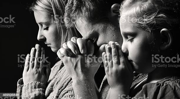 Praying family. Man, woman and child.